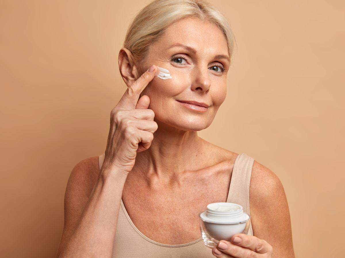 Femme mature prenant soin d'une peau déshydratée avec une crème hydratante
