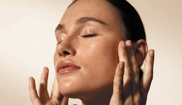 Portrait rapproché d’une peau lumineuse et lisse dans une ambiance éditoriale de soin haut de gamme.